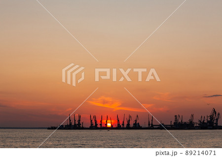 Summer orange sunset of the Sea of Azov against the backdrop of the Berdyansk port. Summer orange sunset of the Sea of Azov against the backdrop of the Berdyansk port. 89214071