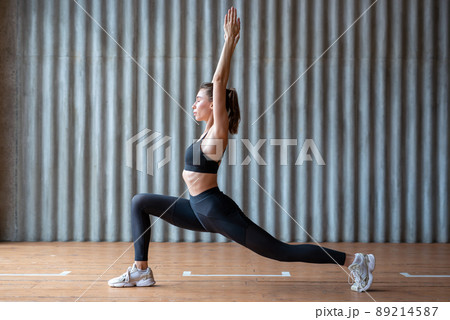 Woman doing yoga working out stretching forward in warrior pose Woman doing yoga working out stretching forward in warrior pose 89214587