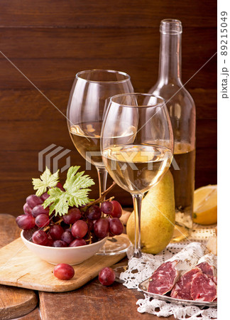 Wine and grapes in vintage setting on wooden table. 89215049