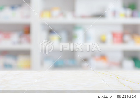Empty white marble counter top with blur pharmacy drugstore shelves background Empty white marble counter top with blur pharmacy drugstore shelves background 89216314