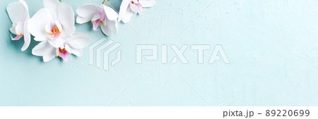 Banner with white tropical orchids on the blue table Banner with white tropical orchids on the blue table 89220699