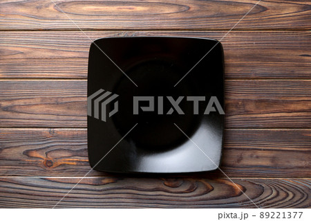 Top view of empty square plate on wooden background. Empty space for your design Top view of empty square plate on wooden background. Empty space for your design 89221377