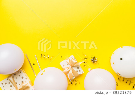 Holiday background with colorful balloon, gift and confetti. Flat lay style. Birthday or party greeting card with copy space 89221379
