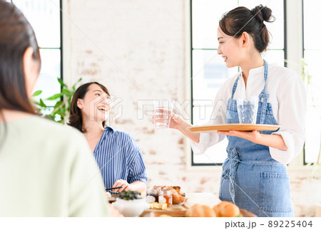 飲食店でアルバイトをする女性 89225404