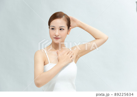 Beauty, youth, freshness and perfect skin. Armpit epilation, laser hair removal. Beautiful woman holding her arms up and showing clean underarms, depilation smooth clear skin in studio. 89225634