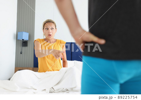 Shocked woman pointing finger at man in shorts Shocked woman pointing finger at man in shorts 89225754