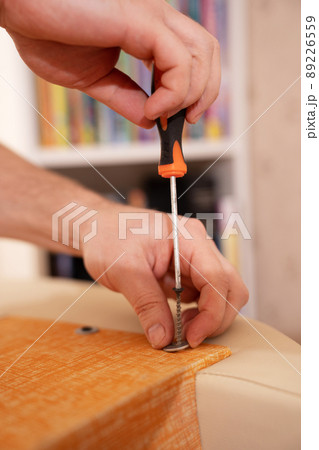 hands with screwdriver assembles furniture. carpenter and handyman services 89226559