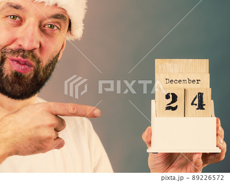 December 24th. Man santa hat holds calender December 24th. Man santa hat holds calender 89226572