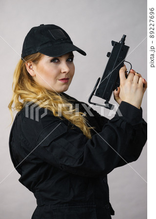 Woman holds gun in hands. 89227696