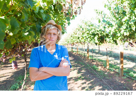 Guy standing with arms folded posing in vineyard Guy standing with arms folded posing in vineyard 89229167