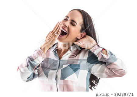 Sleepy and tired woman yawns with mouth wide open and a hand in front of her mouth. Sleepy and tired woman yawns with mouth wide open and a hand in front of her mouth. 89229771