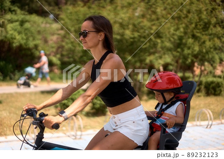 Young woman on a bicycle with little son Young woman on a bicycle with little son 89232123