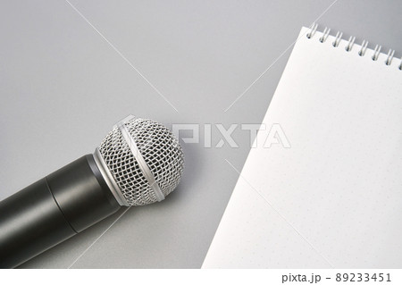 Podcast concept. Black microphone, content notebook, monstera leaf. Audio 89233451