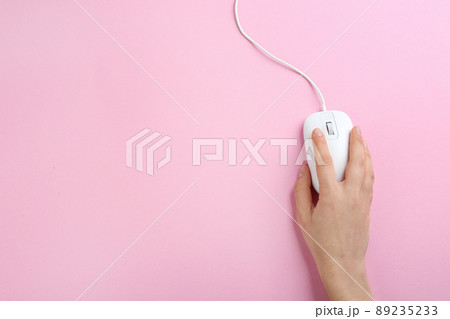 Woman using modern wired optical mouse on pink background, top view. Space for text Woman using modern wired optical mouse on pink background, top view. Space for text 89235233