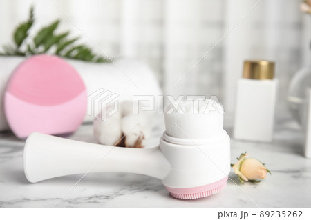 Modern face cleansing brush on marble table. Cosmetic accessory 89235262
