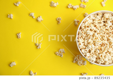 Tasty pop corn on yellow background, flat lay Tasty pop corn on yellow background, flat lay 89235435