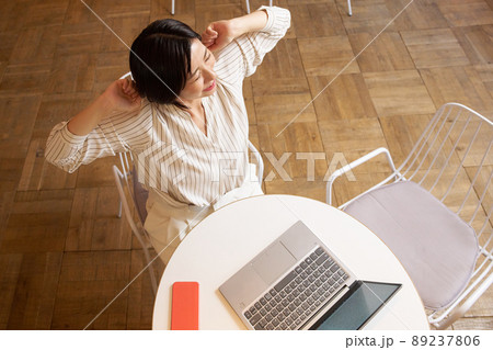 PC作業を中断して伸びをする女性 PC作業を中断して伸びをする女性 89237806