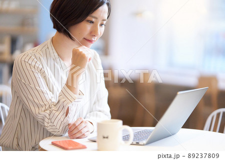 カフェでPCの画面を見つめる若い女性 89237809