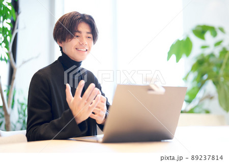 カフェでビデオ通話をしている若い男性 カフェでビデオ通話をしている若い男性 89237814