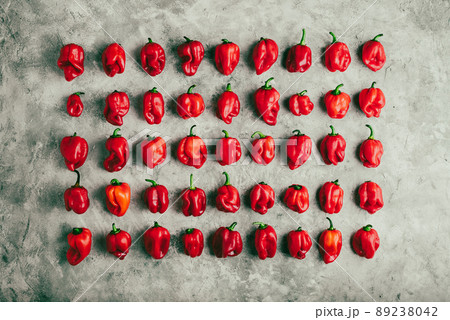 Rows of Red Habanero Peppers on Gray Concrete Surface 89238042