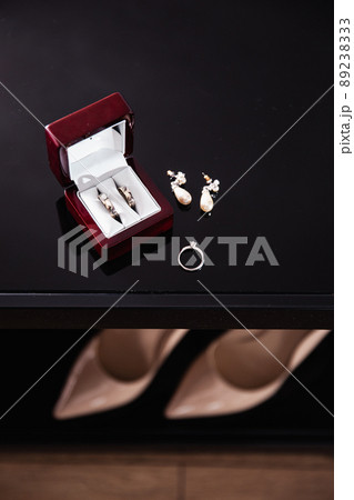 Bridal details - Wedding rings while bride getting ready before the ceremony - Earrings and shoes with heels are in bokeh Bridal details - Wedding rings while bride getting ready before the ceremony - Earrings and shoes with heels are in bokeh 89238333