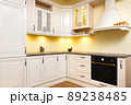 White empty kitchen with light white furniture - Warm lights and nicely decorated wood White empty kitchen with light white furniture - Warm lights and nicely decorated wood 89238485