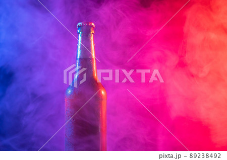 Glass bottle of beer in blue pink mist 89238492