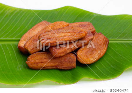 Sun dried bananas on leaf on white background. Sun dried bananas on leaf on white background. 89240474