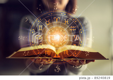 Woman holding a astrology book. Astrological wheel projection, choose a zodiac sign. Astrology esoteric concept. Woman holding a astrology book. Astrological wheel projection, choose a zodiac sign. Astrology esoteric concept. 89240819