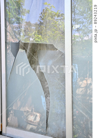 住宅の割れた窓ガラス 89243219