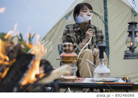 キャンプ場で水タバコを吸う若い女性　シーシャ 89246066