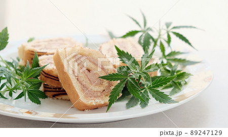Sweet roll with marijuana oil on white plate. Cannabis kitchen Sweet roll with marijuana oil on white plate. Cannabis kitchen 89247129
