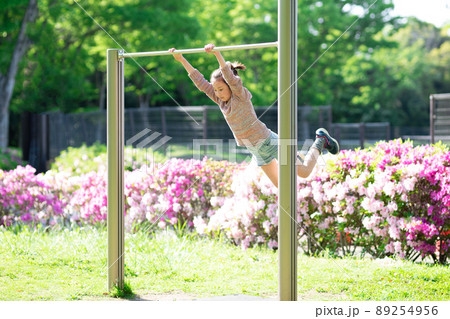 鉄棒で遊ぶ女の子 89254956