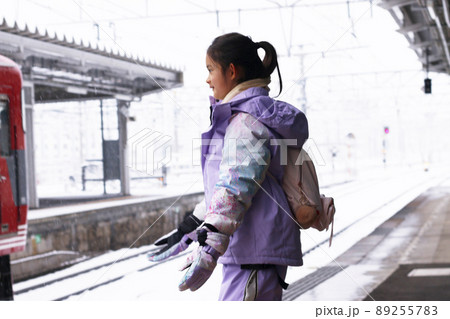 冬休みや冬の家族旅行で雪の降る日に駅のホームで雪が嬉しい女の子 冬休みや冬の家族旅行で雪の降る日に駅のホームで雪が嬉しい女の子 89255783
