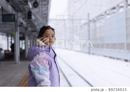 冬の家族旅行で雪の降る日に駅のホームで雪が嬉しい女の子 冬の家族旅行で雪の降る日に駅のホームで雪が嬉しい女の子 89256015