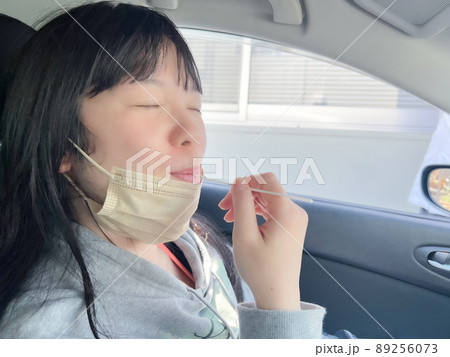 綿棒を使って車内でPCR検査する女性 綿棒を使って車内でPCR検査する女性 89256073