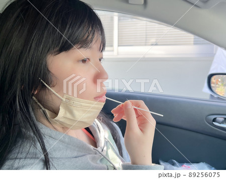 綿棒を使って車内でPCR検査する女性 綿棒を使って車内でPCR検査する女性 89256075