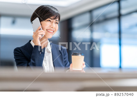 カフェのカウンターで通話をする若い女性 撮影協力：WEEK芝大門（サンフロンティア不動産） 89257040