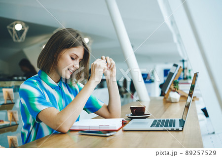 Cheerful female entrepreneur sitting in modern cafe 89257529