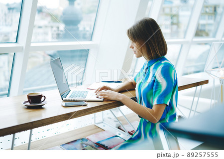Thoughtful female freelancer working on laptop 89257555