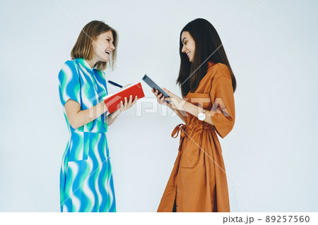 Happy women standing with notebook and tablet Happy women standing with notebook and tablet 89257560