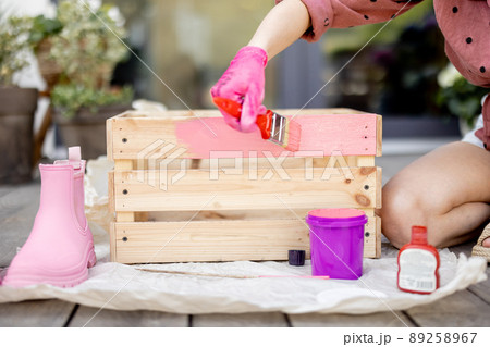 Woman painting wooden box in pink color, DIY concept Woman painting wooden box in pink color, DIY concept 89258967
