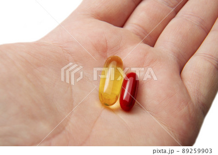 Two medicines capsules tablets are in the man's hand decision-making medicine. 89259903