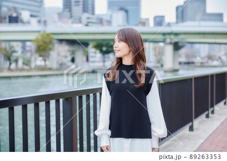 川沿いの遊歩道を歩く女性 89263353