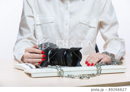 Copyright. The camera is chained to the photographer's hand. The concept of protecting the photographer from theft of his photos. Isolated on white background. Copyright. The camera is chained to the photographer's hand. The concept of protecting the photographer from theft of his photos. Isolated on white background. 89266627