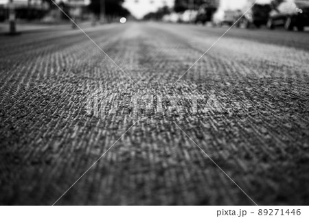 Low angle shot across a scarified street under construction with lanes on either side blocked off. 89271446