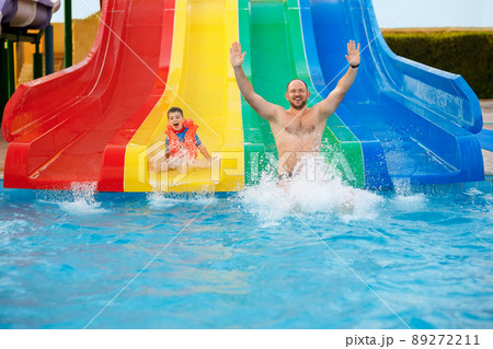 father and son on water slide in the aqua park 89272211