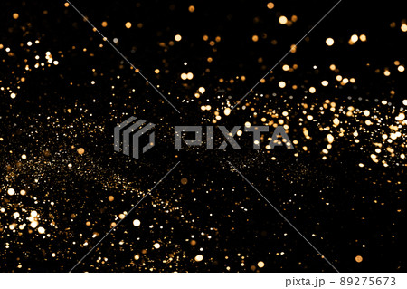 Black festive background. Abstract scattering of gold sparkles on black. Holiday backdrop, selective focus Black festive background. Abstract scattering of gold sparkles on black. Holiday backdrop, selective focus 89275673