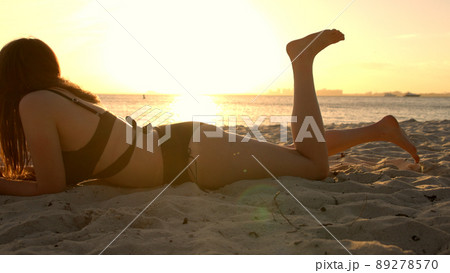 Woman relaxes at the beach of Miami at sunset - beautiful silhouette shot 89278570