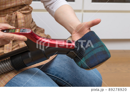 【サイクロンクリーナーでスリッパのゴミを吸い取るミドル主婦】 89278920